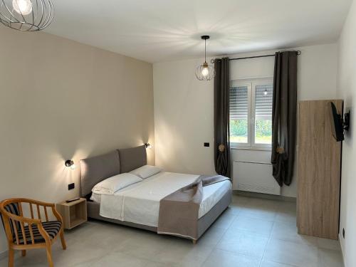 a bedroom with a bed and a chair and a window at La casa dei Coloni in Nola