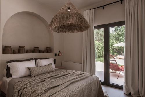 a bedroom with a bed and a large window at Kokkinochoma Slow Living Villa in Lagópodhon