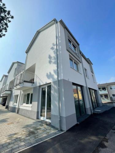 a white building with glass doors on a street at White House Apartments in Kappel-Grafenhausen