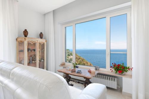 a living room with a white couch and a large window at Hotel Desiree in Sorrento