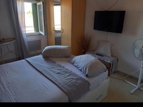 une chambre avec un lit et une télévision à écran plat dans l'établissement Maison 5 personnes, au Pontet