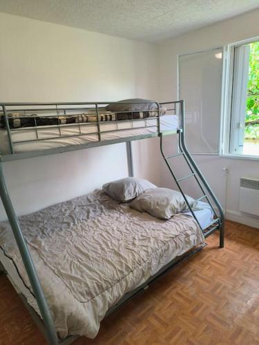 une chambre avec deux lits superposés dans une pièce dans l'établissement Maison Charmante et Jardin Privé à Gagny - Proche Paris, à Gagny