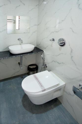 ナーシクにあるHotel The Marionのトイレと洗面台を備えた白いバスルーム
