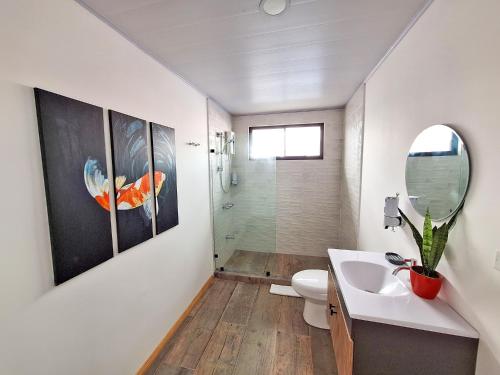 a bathroom with a sink and a toilet and a mirror at Jungla Urbana, BnB in Pavas