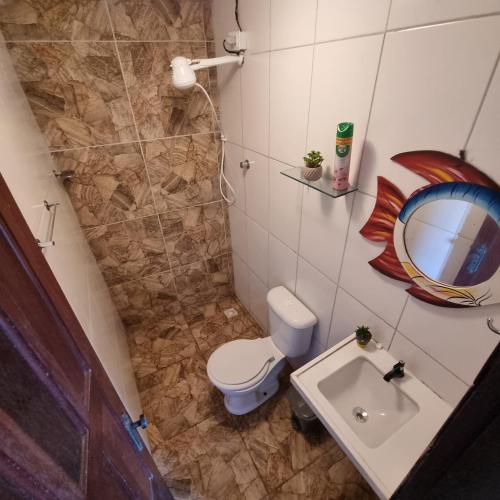 a small bathroom with a toilet and a sink at Chalé Raiz da Serra in Gravatá