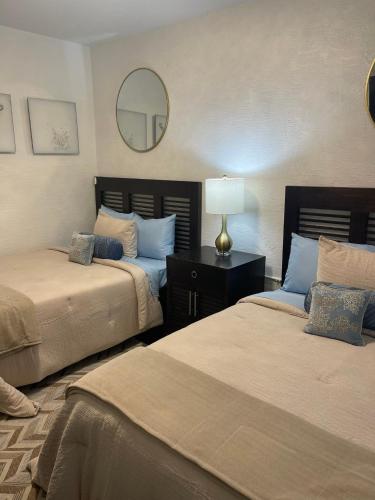 a bedroom with two beds and a mirror at Radiant Retreat #7 in Daytona Beach