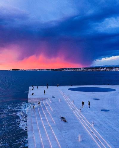 a group of people walking on a pier in the water at Mara in Zadar