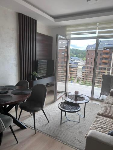 a living room with a couch and a table and chairs at Sunny view in Zlatibor