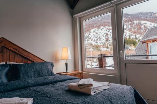 a bedroom with a bed with a towel on it at Ski Sur Apartments in San Carlos de Bariloche