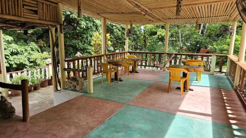 a patio with tables and chairs on a porch at Hotel - Museo Xibalba in Palenque