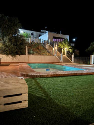 a swimming pool in a yard at night at Casa rural DOS ENCINAS in Andújar