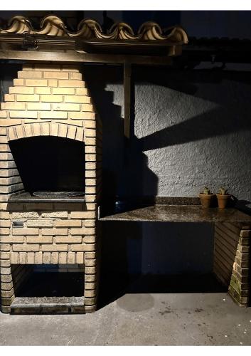 a brick oven with a shadow on a wall at Casa Ilha| beira mar, piscina aquecida, 4 suítes in Marechal Deodoro