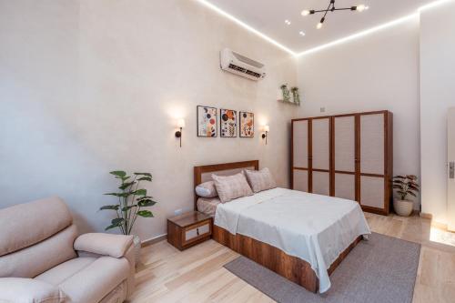 a bedroom with a bed and a couch at Moderne Suite I Smart-TV I Klimaanlage I Zamalek in Cairo
