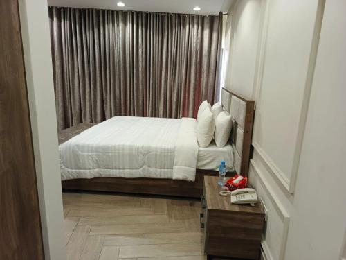 Jhang SadrにあるLDS Mall Luxurious Penthouse - Jhangのベッドと電話付きのテーブルがある寝室
