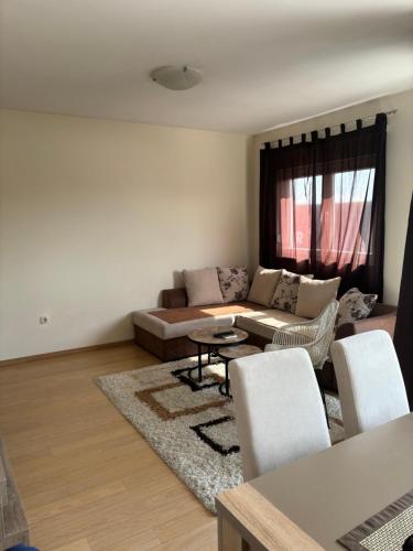 a living room with a couch and a table and chairs at Apartment Ana in Podgorica