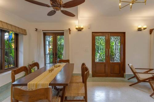 a dining room with a table and chairs and a ceiling fan at Casa Dolce Vita 4 bed villa with a pvt pool in North Goa in Bardez