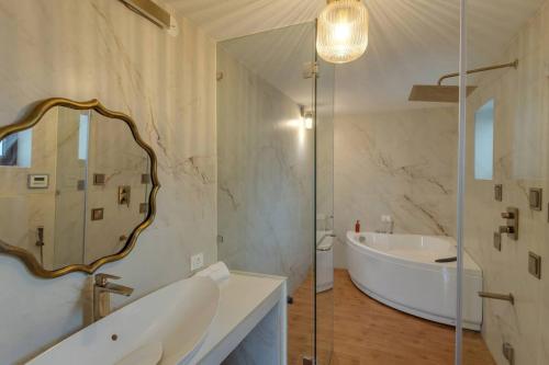 a bathroom with a tub and a sink and a mirror at Casa Dolce Vita 4 bed villa with a pvt pool in North Goa in Bardez