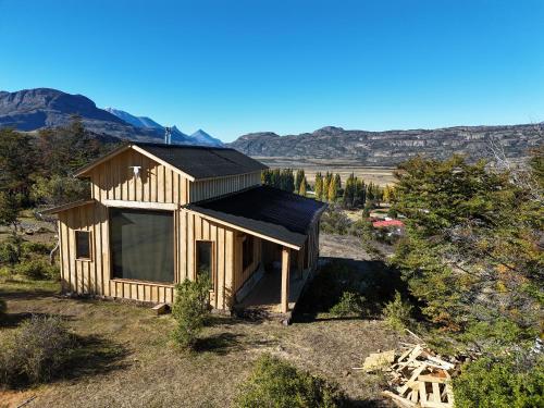 a small wooden house with a black roof at Casa La Lenga Patagonia in Villa Cerro Castillo