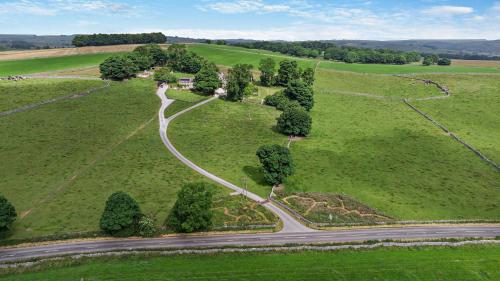 an aerial view of a road in a field with trees at Bolehill Farm Cottages in Bakewell