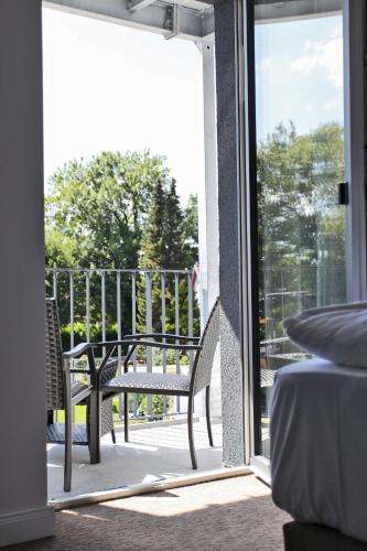a sliding glass door leading to a patio with a bench at Sandbank Hotel & Appartements Lubmin in Lubmin