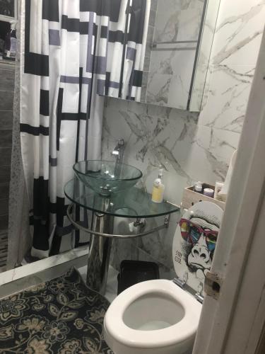 a bathroom with a toilet and a glass table at Josiane Peace of stay in Miami