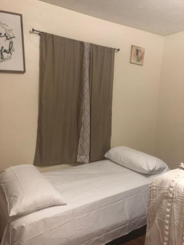 a bed in a room with a window with avertisement at Josiane Peace of stay in Miami