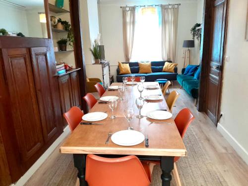 une salle à manger avec une longue table avec des verres à vin dans l'établissement 4 Ch - 10 pers - Grande Maison - Parking - Jardin - BBQ, à Amiens