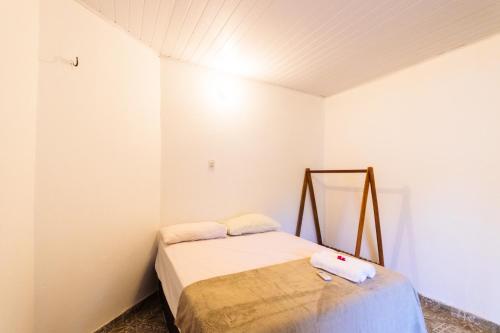 a small bedroom with a bed with white walls at Casamarias duplo in Barra Grande