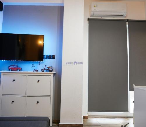 sala de estar con TV y puerta corredera en Charlotte Townhouse, en Komotiní