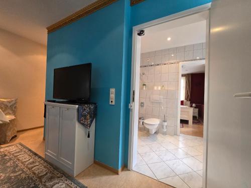 a bathroom with a blue wall and a toilet at Hotel & Café Schachtenburg in Schlitz