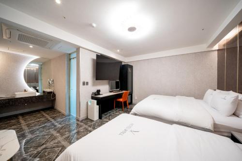 a hotel room with two beds and a desk at Hotel Voll in Seoul