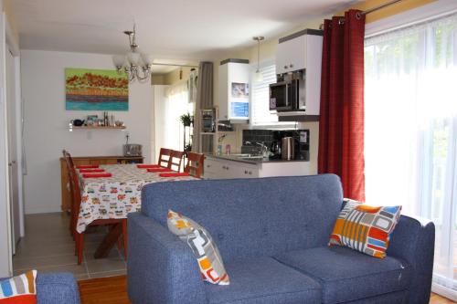 a living room with a blue couch and a table at Gite Confort in Quebec City