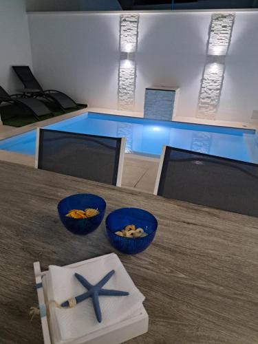 a table with two bowls of food on it with a starfish at VILLA PERLA del SALENTO con piscina in Lido Marini