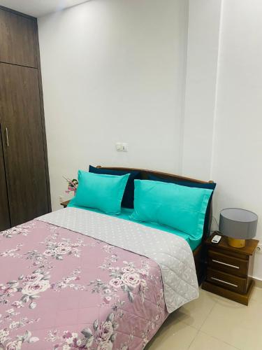 a bedroom with a bed with blue and pink pillows at Marie in Grand-Bassam