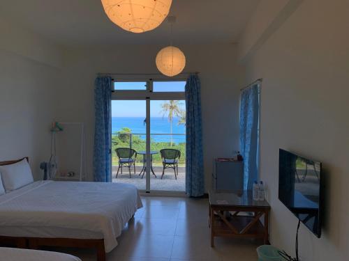 a bedroom with a bed and a view of the ocean at 春夏秋冬海景民宿Ocean View Motel in Chenggong