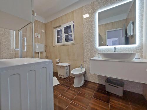a bathroom with a tub and a sink and a toilet at Holiday house with pool and whirlpool Sara in Betina