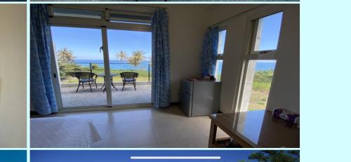 a room with a view of the ocean from a bedroom at 春夏秋冬海景民宿Ocean View Motel in Chenggong