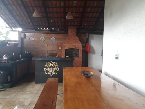 a kitchen with a wooden table and a brick oven at casa cachoeira in Brasília