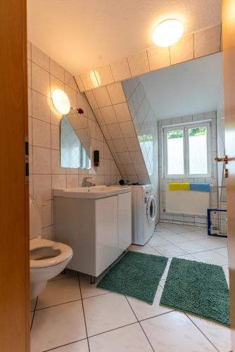 a bathroom with a toilet sink and a washing machine at Dachwohnung am Schlosspark in Wiesbaden