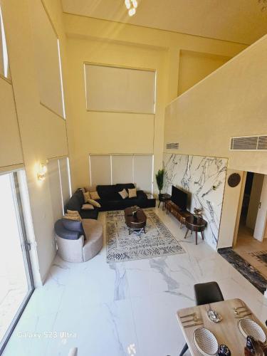 a living room with a couch and a table at B36 Loft Apartment Samarah Resort in Sowayma
