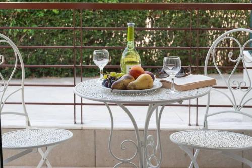 a table with a plate of fruit and a bottle of wine at Bijou by Sea in Perea