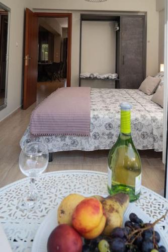 a table with a plate of fruit and a bottle of wine at Bijou by Sea in Perea