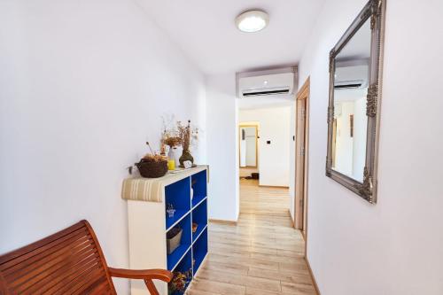 a hallway with a blue dresser and a mirror at Marcos Apartments City Center - Self check-in in Reşiţa