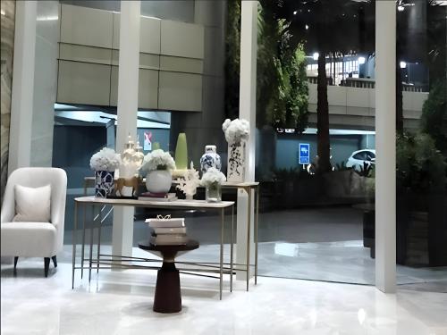 a table with vases and flowers on it in a building at Luxurious 1 Icon 3BR Apartment in Tunjungan Plaza 6 Surabaya City Centre by Le Ciel Hospitality in Surabaya