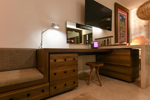 a room with a desk with a television and a stool at Hotel Xcaret Mexico All Parks All Fun Inclusive in Playa del Carmen