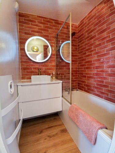 une salle de bain avec une baignoire, un lavabo et un miroir dans l'établissement La Montagnarde avec vue imprenable - station Doucy Valmorel - 4pers, à La Lechere