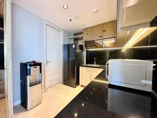 a kitchen with black and stainless steel appliances at Luxurious 1 Icon 3BR Apartment in Tunjungan Plaza 6 Surabaya City Centre by Le Ciel Hospitality in Surabaya