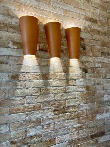 four brown pots on a brick wall at Casa La Salsa in Pisticci