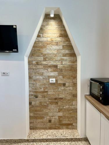 a stairway with a brick wall in a kitchen at Casa La Salsa in Pisticci