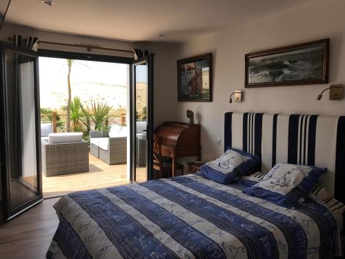 une chambre avec un lit et une porte coulissante en verre dans l'établissement Villa de la dune, à Seignosse